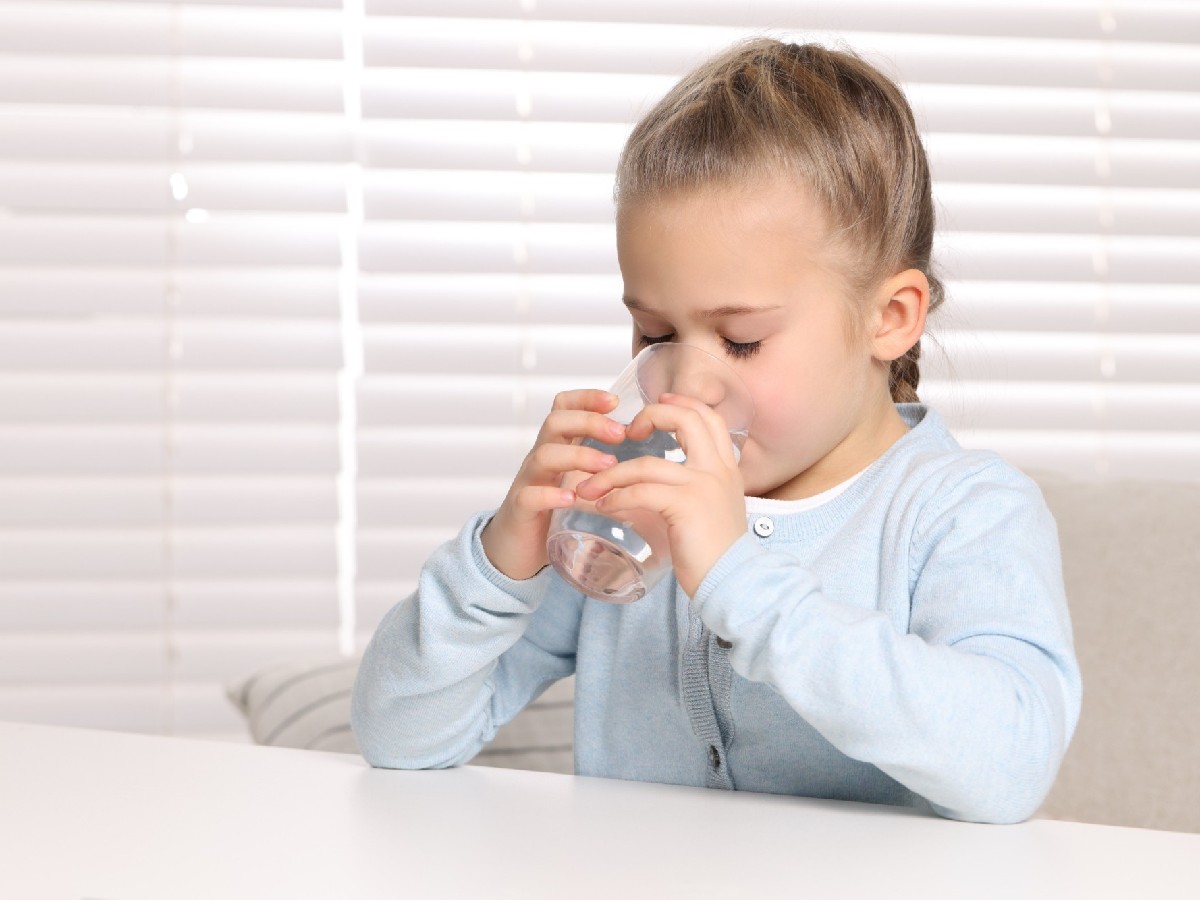 Dziewczynka pije wodę ze szklanki