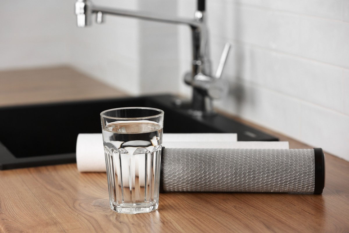Szklanka wody na blacie kuchennym z filtrami