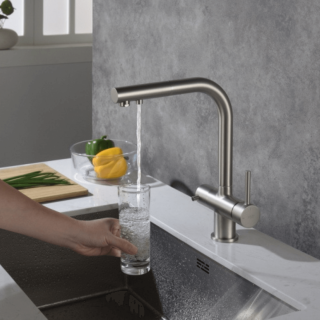 Nalewanie filtrowanej wody do szklanki z baterii czterodrożnej